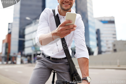 Image of man with smartphone and fixed gear bike on street