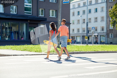 Image of teenage couple with skateboards on city crosswalk