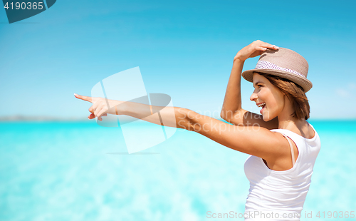 Image of happy young woman in hat on summer beach