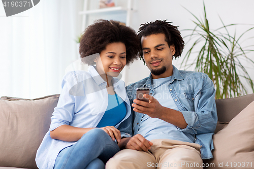 Image of happy couple with smartphones at home