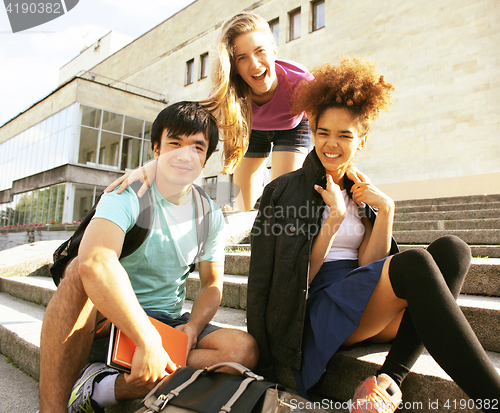 Image of cute group of teenages at the building of university with books 