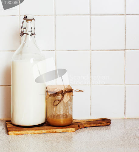 Image of morning food concept: milk and honey in glass on wood board ready for breakfast 