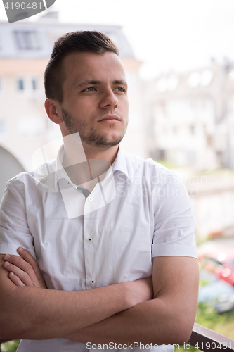 Image of man standing at balcony