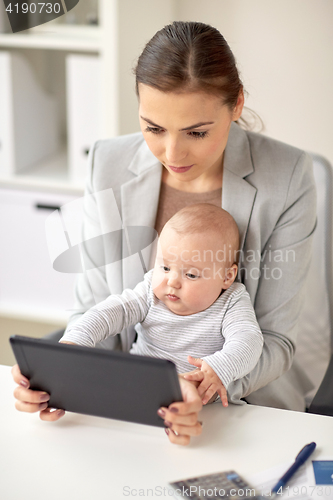 Image of businesswoman with baby and tablet pc at office