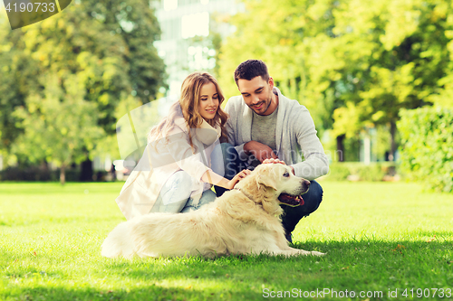 Image of happy couple with labrador dog walking in city