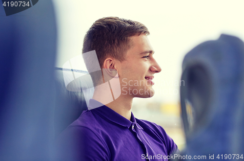 Image of happy young man sitting in travel bus