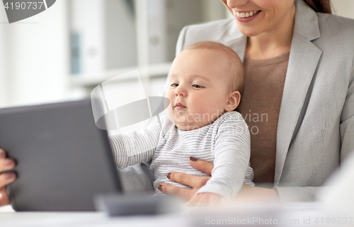 Image of businesswoman with baby and tablet pc at office