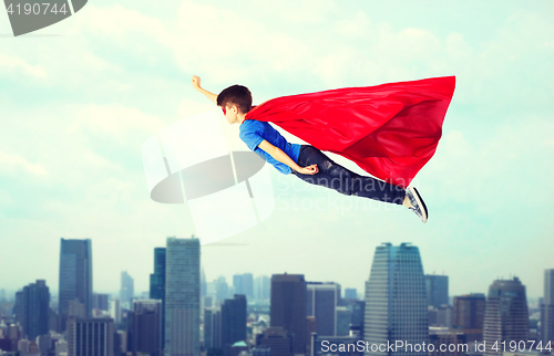 Image of boy in red superhero cape and mask flying on air