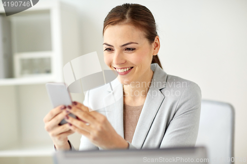 Image of businesswoman with smartphone at office