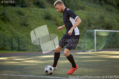 Image of soccer player playing with ball on football field