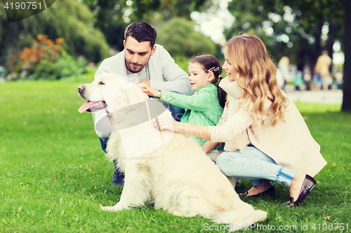 Image of happy family with labrador retriever dog in park