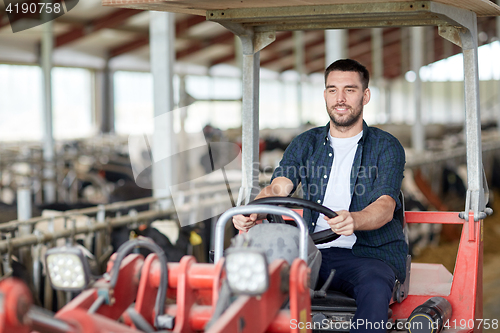 Image of man or farmer driving tractor at farm