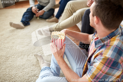 Image of close up of man with friends and popcorn at home