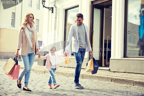 Image of happy family with child and shopping bags in city