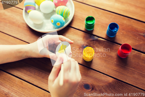 Image of close up of woman hands coloring easter eggs