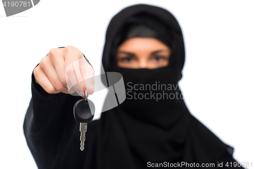 Image of muslim woman in hijab with car key over white