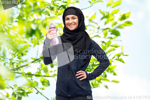 Image of muslim woman with water bottle doing sport