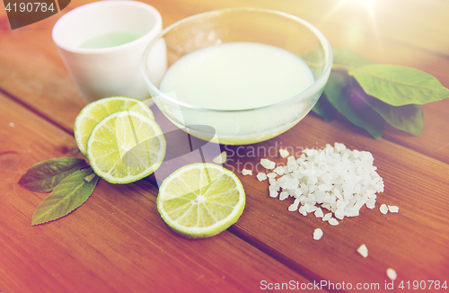 Image of close up of body lotion, cream and salt on wood