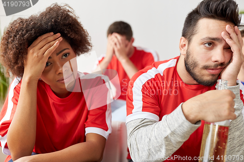 Image of sad friends or football fans at home