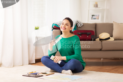 Image of happy woman with money and travel map at home