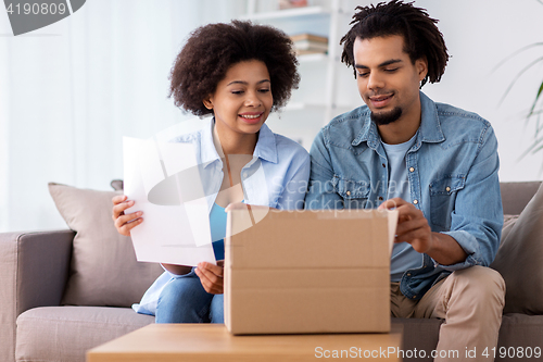 Image of happy couple with parcel box and paper form home