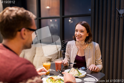 Image of happy couple eating dinner at vegan restaurant