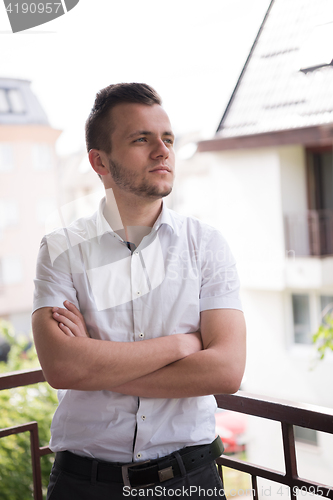 Image of man standing at balcony