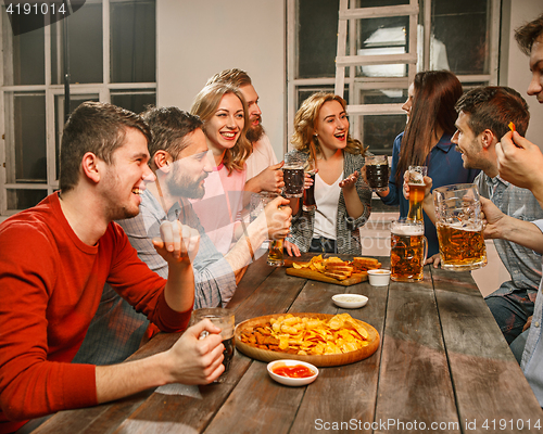 Image of Group of friends enjoying evening drinks with beer