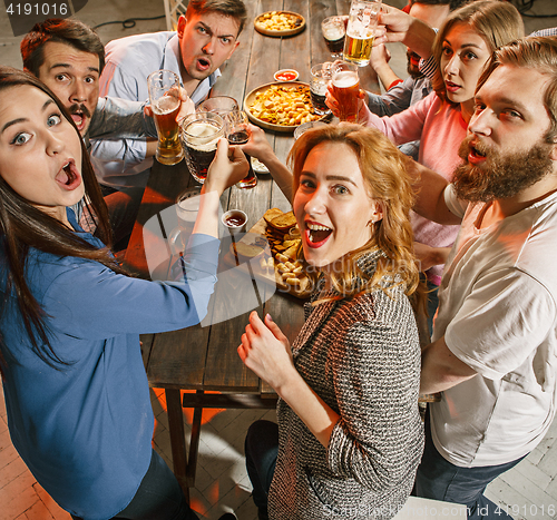 Image of Group of friends enjoying evening drinks with beer