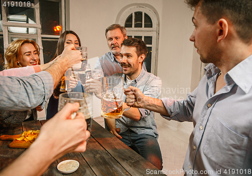 Image of Group of friends enjoying evening drinks with beer