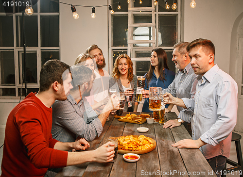 Image of Group of friends enjoying evening drinks with beer