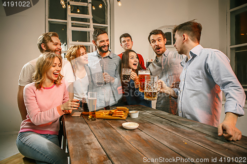 Image of Group of friends enjoying evening drinks with beer