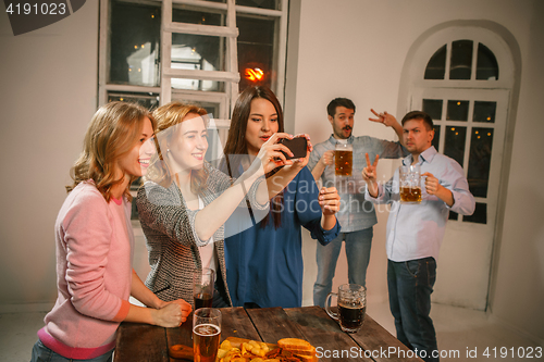 Image of Group of friends enjoying evening drinks with beer