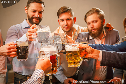 Image of Group of friends enjoying evening drinks with beer