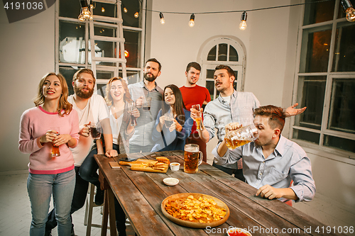 Image of Group of friends enjoying evening drinks with beer