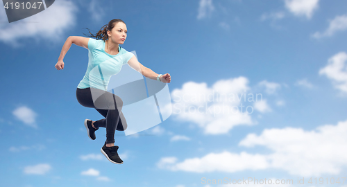 Image of happy sporty young woman jumping in air