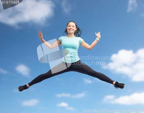 Image of happy smiling sporty young woman jumping in air