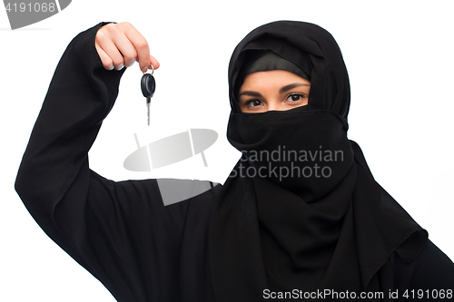 Image of muslim woman in hijab with car key over white