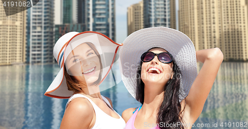 Image of happy young women in hats on summer beach