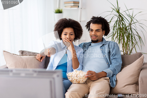 Image of couple with popcorn watching tv at home