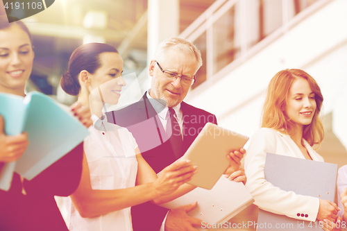 Image of business team with tablet pc and folders at office