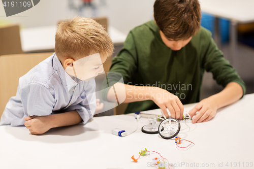 Image of happy children building robots at robotics school