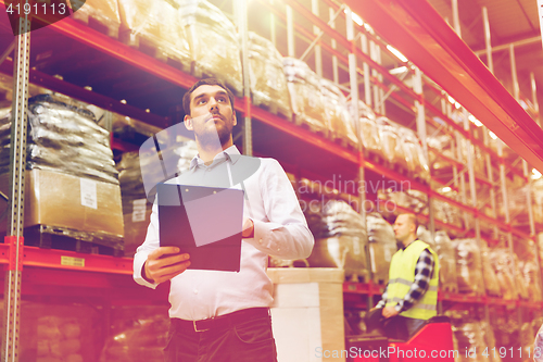 Image of businessman with clipboard at warehouse