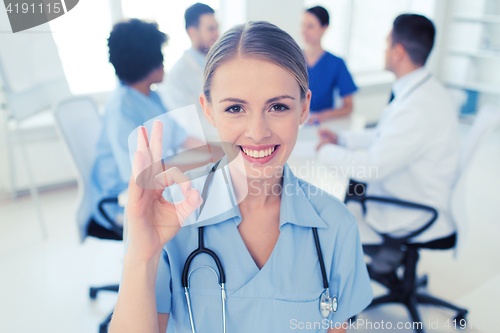 Image of happy doctor over group of medics at hospital