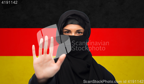 Image of muslim woman in hijab showing stop sign