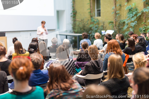 Image of Woman giving presentation in lecture hall at university.