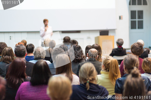 Image of Woman giving presentation in lecture hall at university.