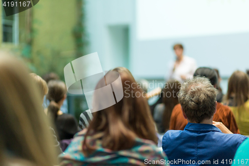 Image of Woman giving presentation in lecture hall at university.