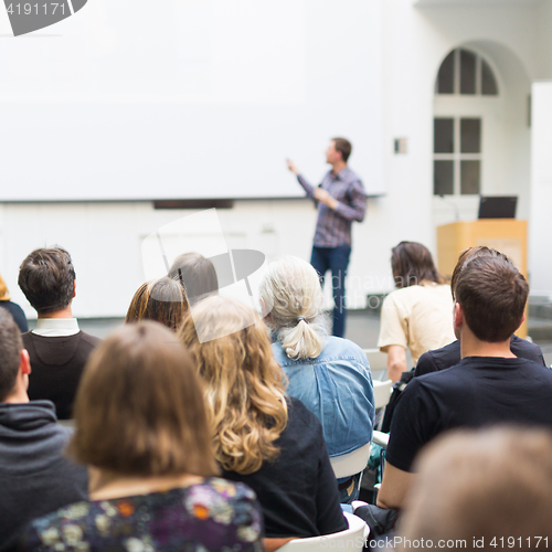 Image of Man giving presentation in lecture hall at university.