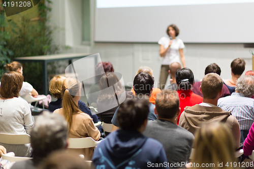 Image of Woman giving presentation in lecture hall at university.